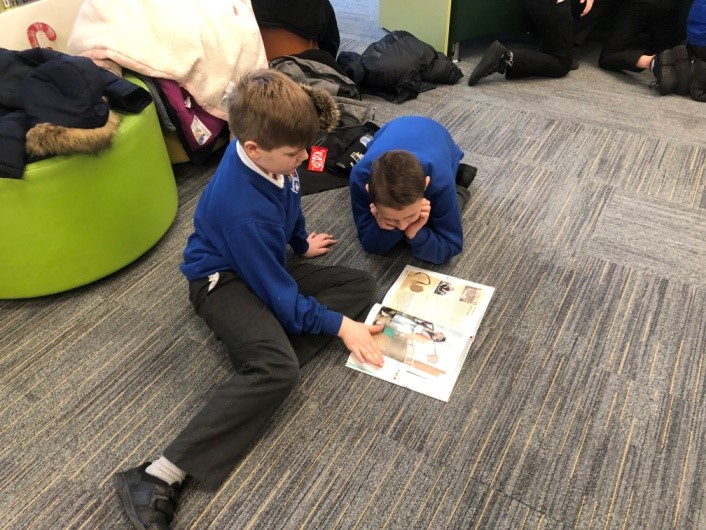boys on floor looking at book